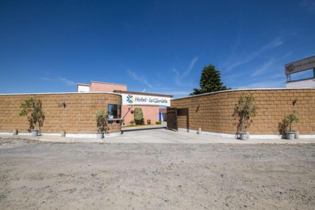 a brick building with a sign in front of it at OYO Hotel La Glorieta, Huichapan in Huichapan