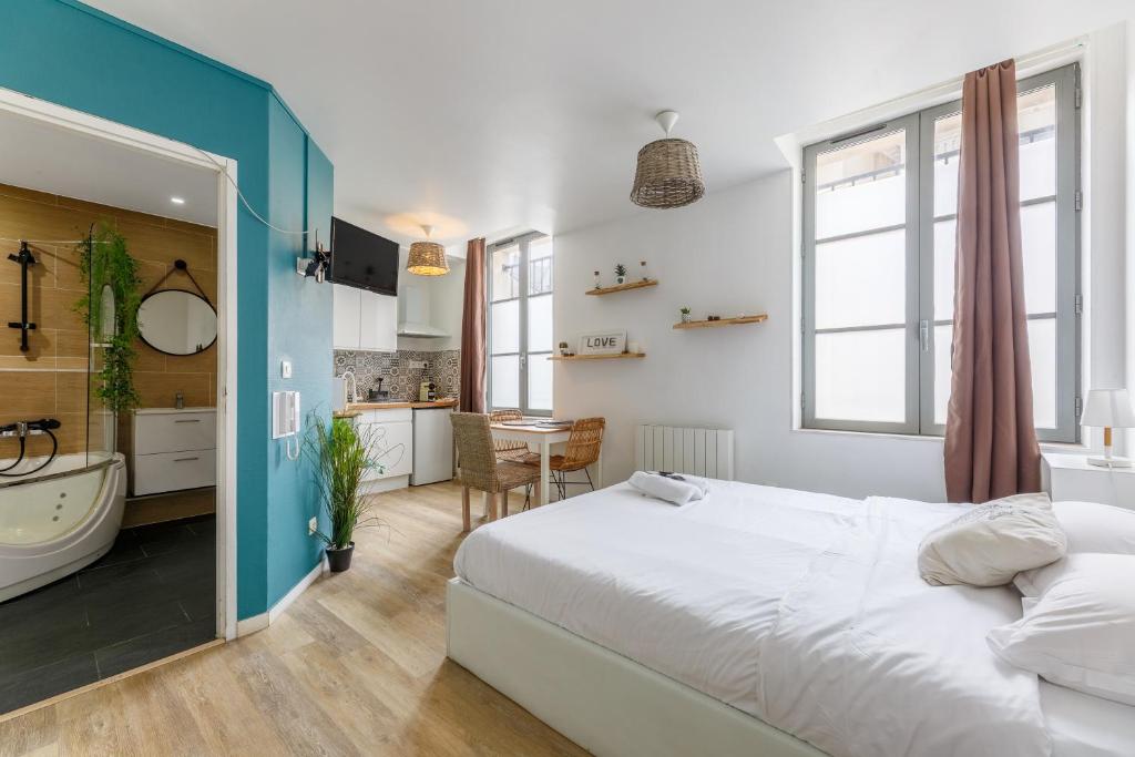 a bedroom with a large bed and a bathroom at Nid Amour Cabane et Spa Privatif in Rouen