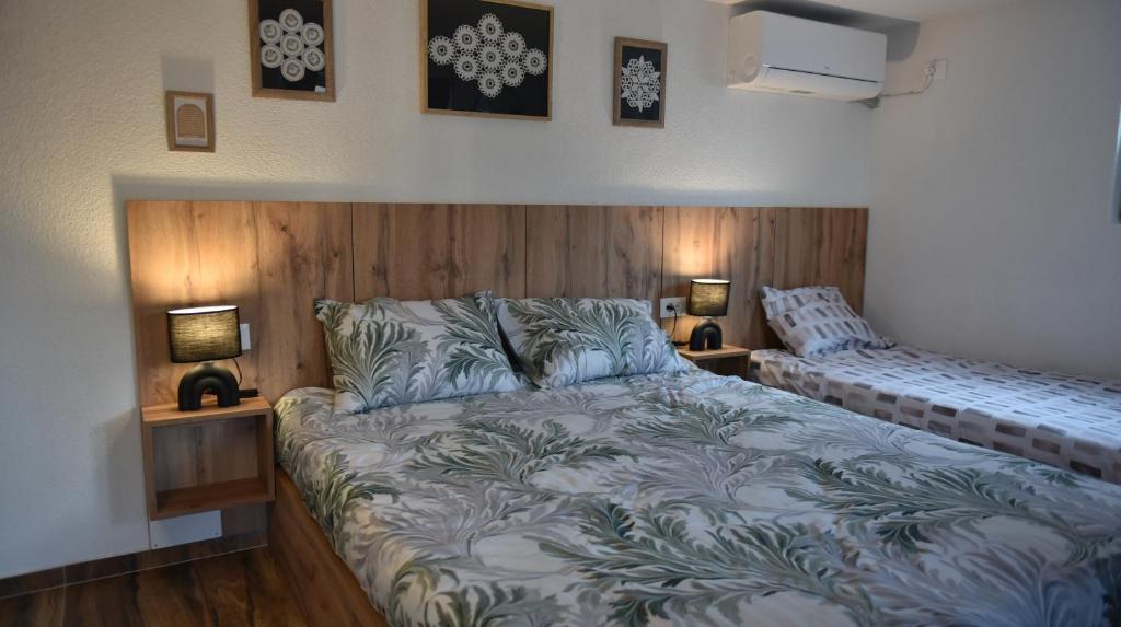 a bedroom with a bed and two lamps on the wall at Lex Apartments KS in Prizren