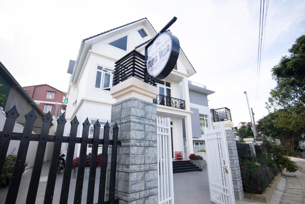 a white house with a clock on the front of it at HUNA's HOUSE in Da Thanh