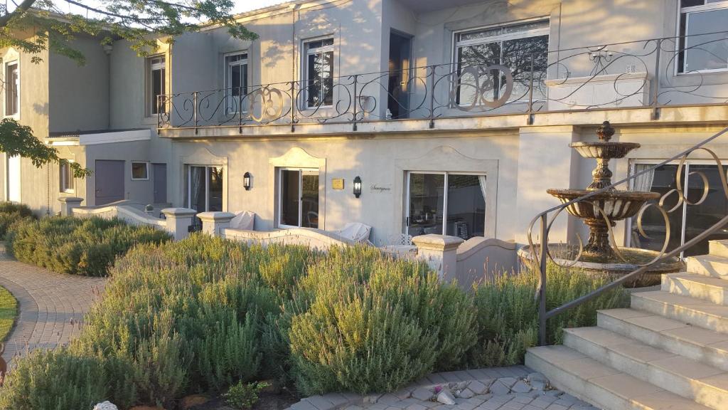 a house with a staircase and a fountain in front of it at Dieu Donne in Stellenbosch