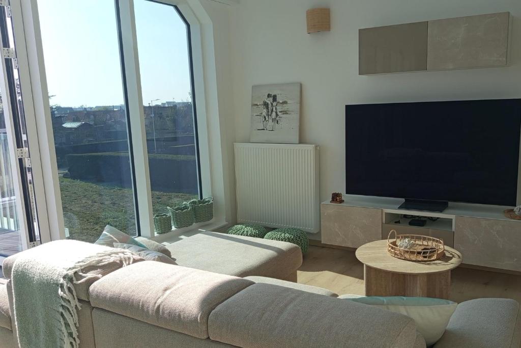a living room with a couch and a flat screen tv at Spacious and bright 125m2 apartment in Berck in Berck-sur-Mer