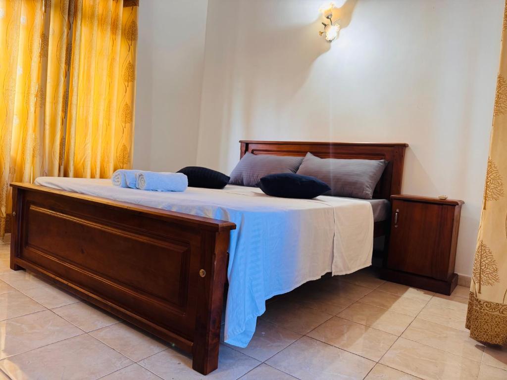 a bedroom with a bed with blue pillows on it at The Layover Hostel in Katunayaka