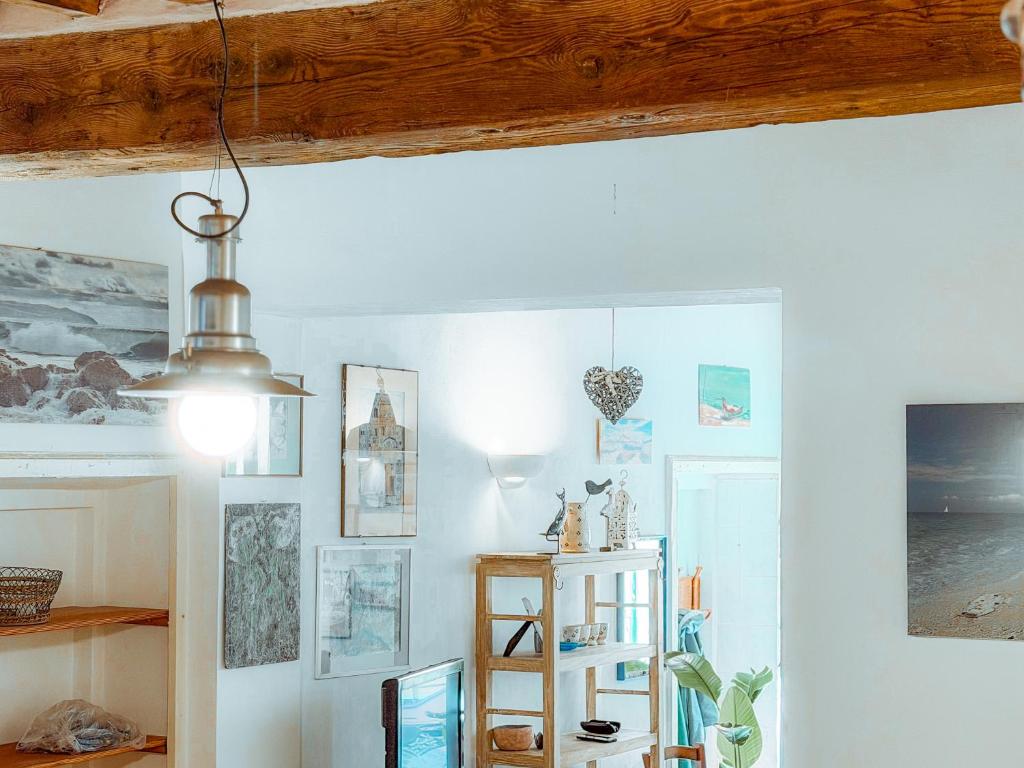 a room with a white wall with pictures on it at Casa dell'Artista - HelloElba in Portoferraio