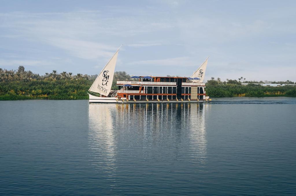 a boat with two sails on the water at Mazaj Meroot Dahabiya - Every Monday from Luxor in Luxor