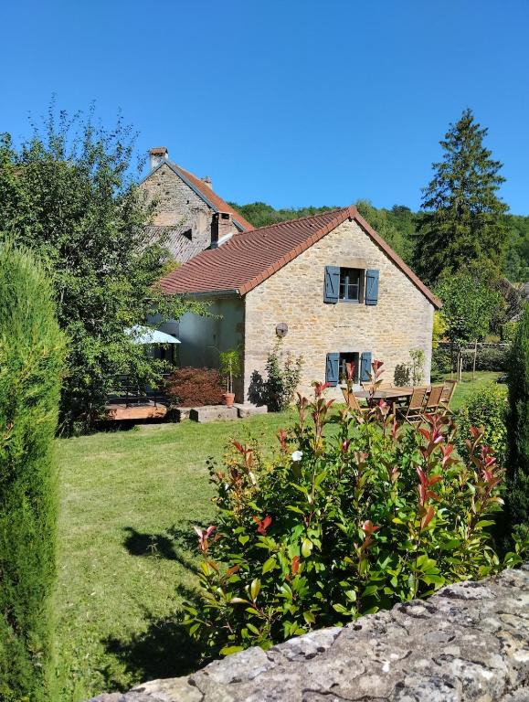a stone house with a garden in front of it at Le petit Moulin de Drée in Drée