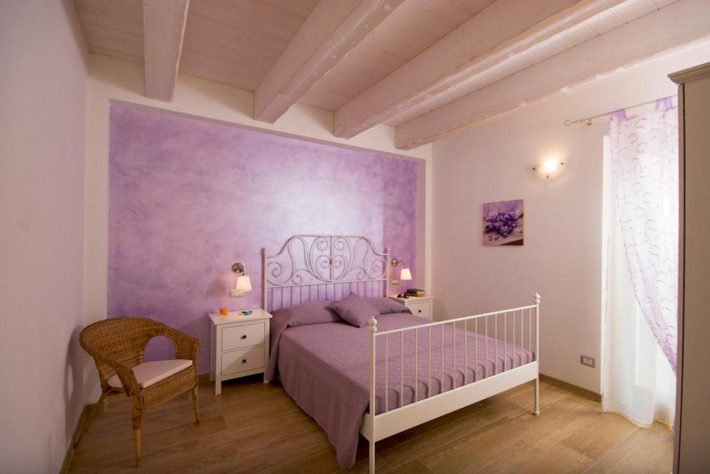 a bedroom with a bed and a purple wall at La Terrazza del Conero La Ginestra in Sirolo