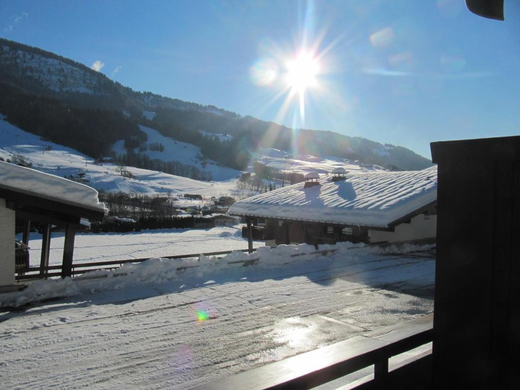 un soleil brillant sur le toit d'un bâtiment dans la neige dans l'établissement Le Clos d'Arly, à Praz-sur-Arly