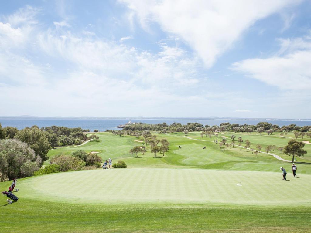 a group of people playing golf on a golf course at Cas Ferrer Nou Hotelet in Alcudia