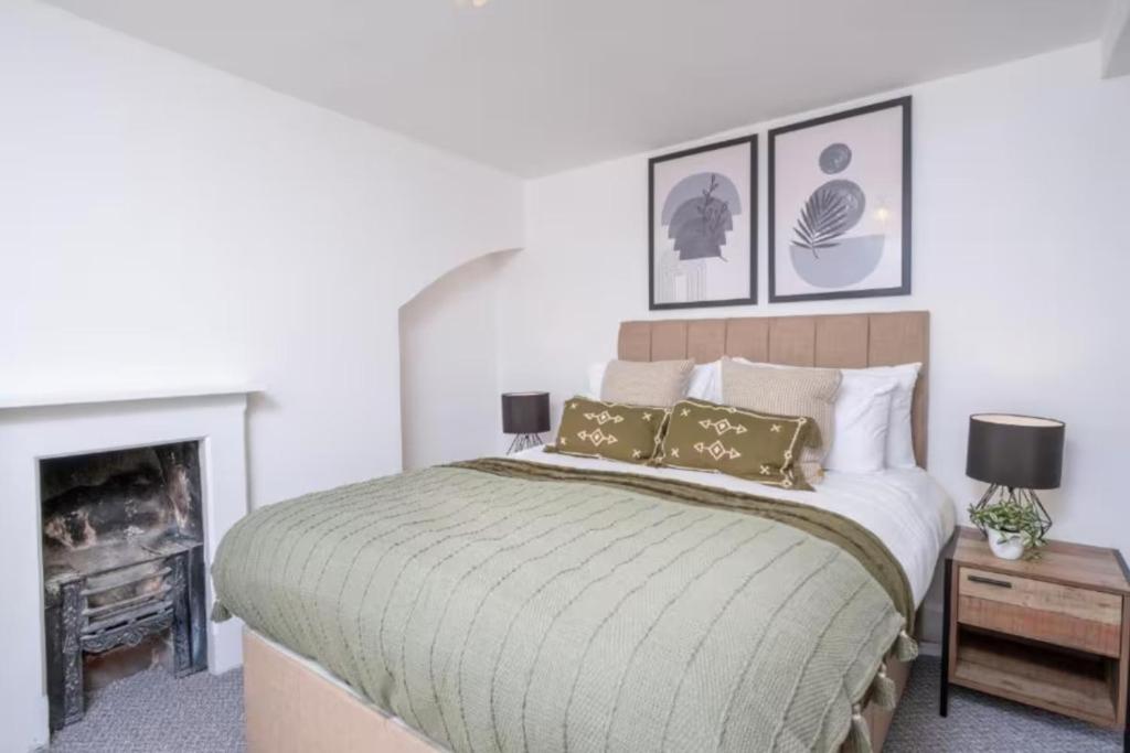 a bedroom with a large bed and a fireplace at Central Stroud 3-Bedroom Flat with Fast WiFi in Stroud