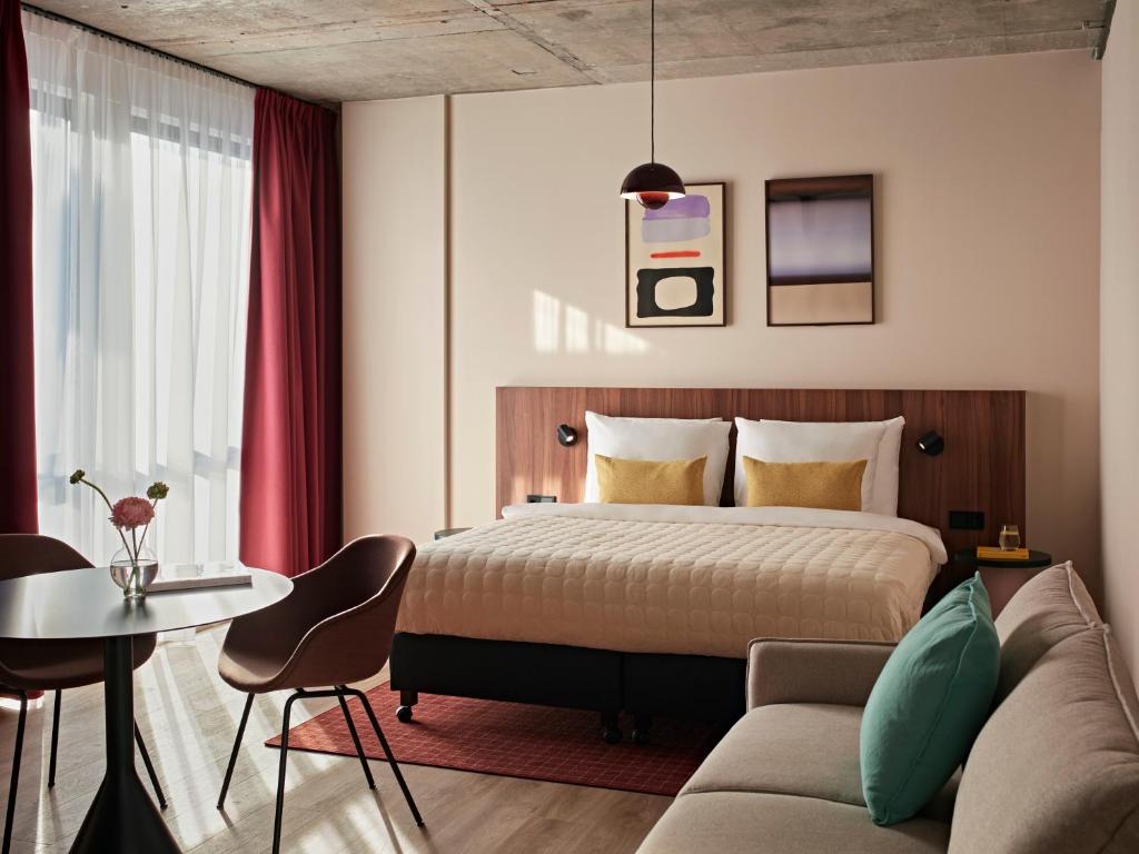 a hotel room with a bed and a couch at Numa Rotterdam Coolsingel in Rotterdam