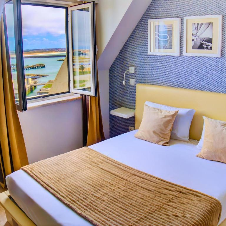 ein Schlafzimmer mit einem Bett und einem Fenster in der Unterkunft Hotel Nobu Peniche in Peniche