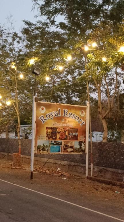 a sign on the side of a street with lights at Royal Resort in Indore