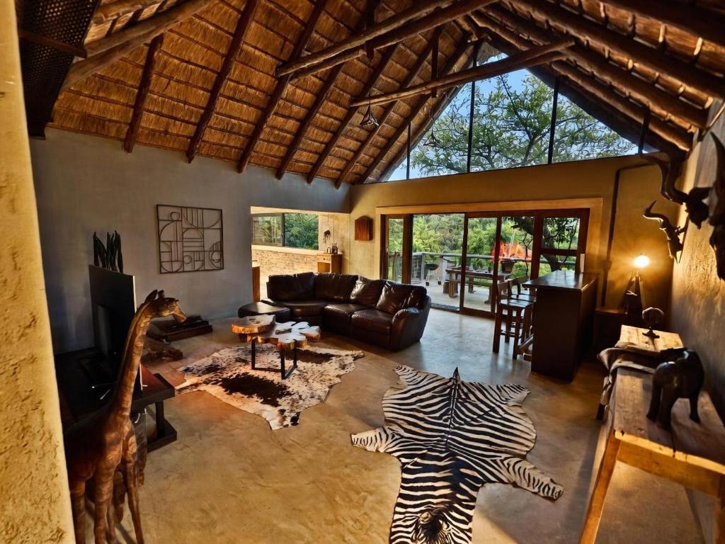 a living room with a giraffe and a couch at Syeta Bush Lodge - Luxury Bush Villa in Crocodile Valley Estates