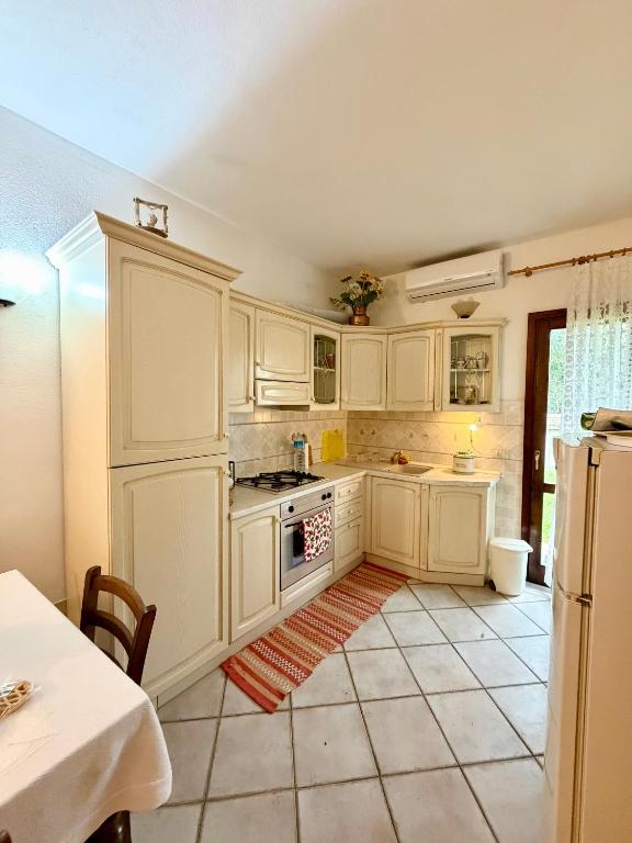 a kitchen with white cabinets and a stove at Casa vacanza Oleandro in San Teodoro