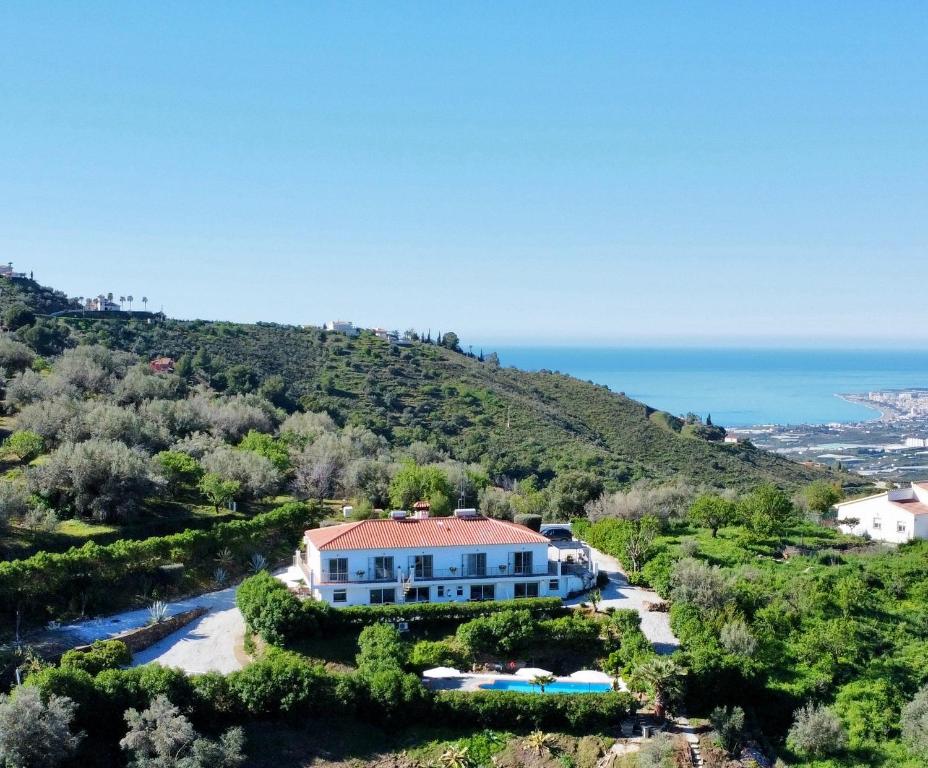 a house on a hill next to the ocean at Sobremesa Boutique in Sayalonga