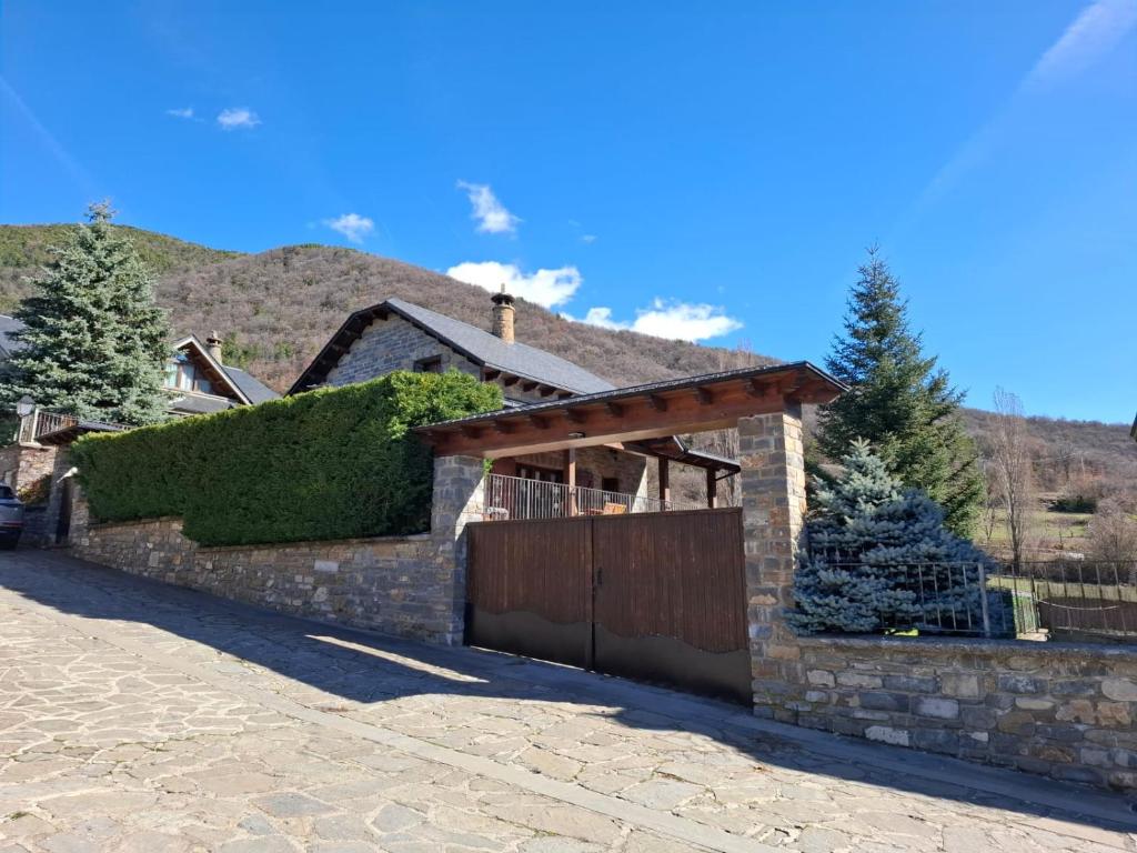 a brick house with a hedge on the side of it at El balcón de Cotefablo Chalet de Montaña con Jardín y Vistas - Arafita Apartamentos in Gavín