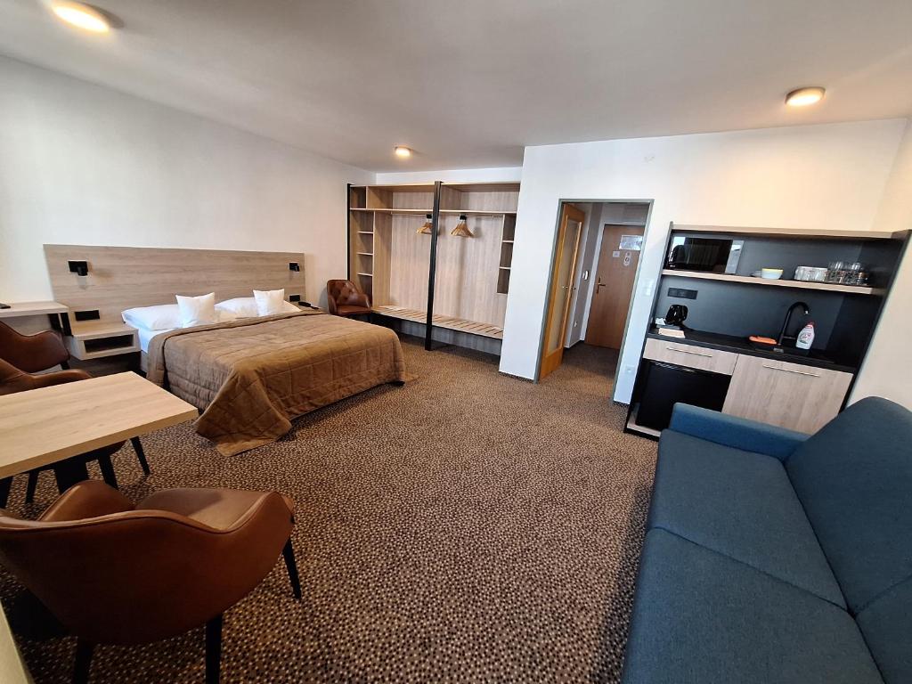 a hotel room with a bed and a couch at Hotel Avion in Prague