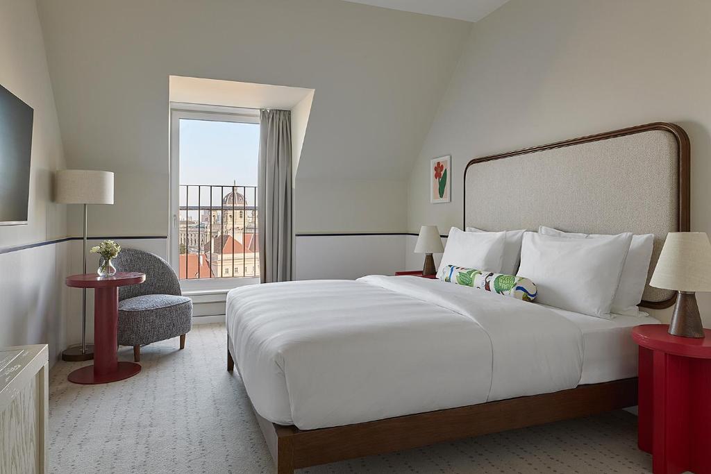 a bedroom with a large white bed and a window at Miiro Spittelberg NEW OPENING in Vienna