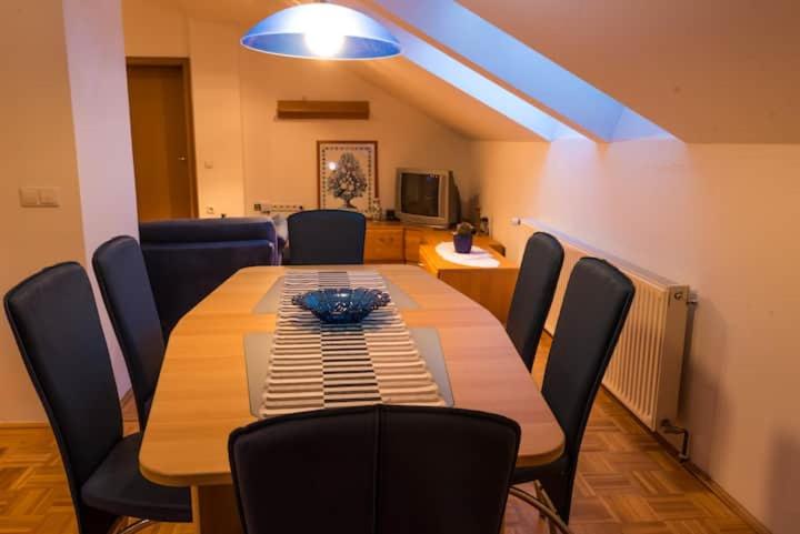 a dining room with a wooden table and chairs at Goričko Homes in Mačkovci