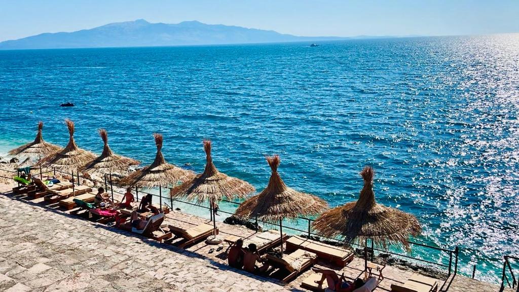 a group of straw umbrellas on a beach at LOOKOUT Apartments 2 in Sarandë