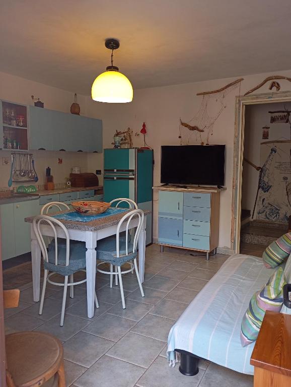 a kitchen with a table and chairs and a television at In Sardegna da Anna Rita in Scano Montiferro