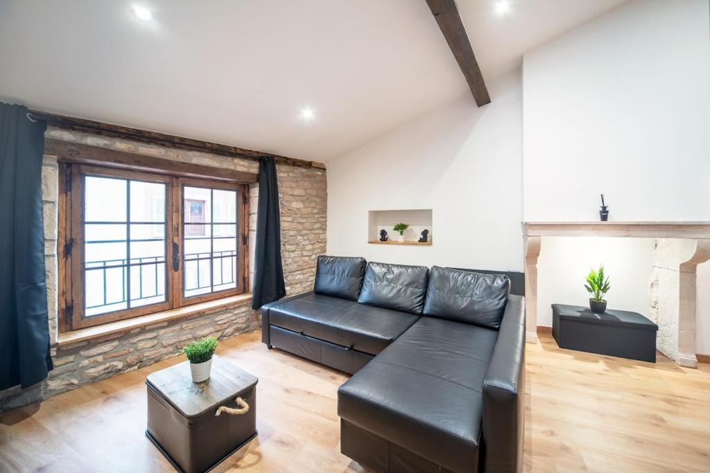a living room with a black leather couch at Myappart71- Loft - centre ville in Mâcon