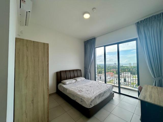 a bedroom with a bed and a large window at PeaceStay in Sandakan