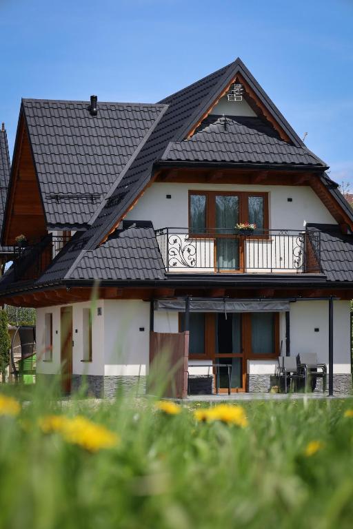 a white house with a black roof at Magia Gór -500m do Gorący Potok i Term Szaflary-rabaty in Szaflary