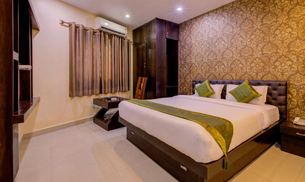 ein Schlafzimmer mit einem großen Bett in einem Zimmer in der Unterkunft Treebo Archie Regency in Ranchi