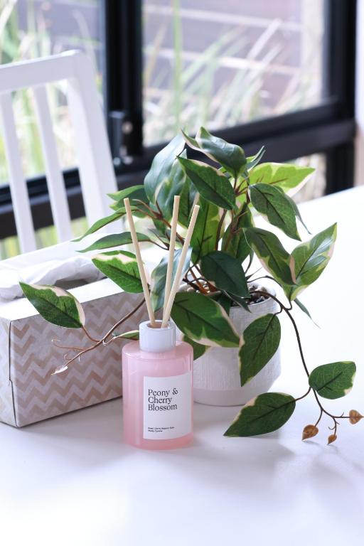 a pink candle and a potted plant on a table at Sweet Home Property Forrestfield in Perth