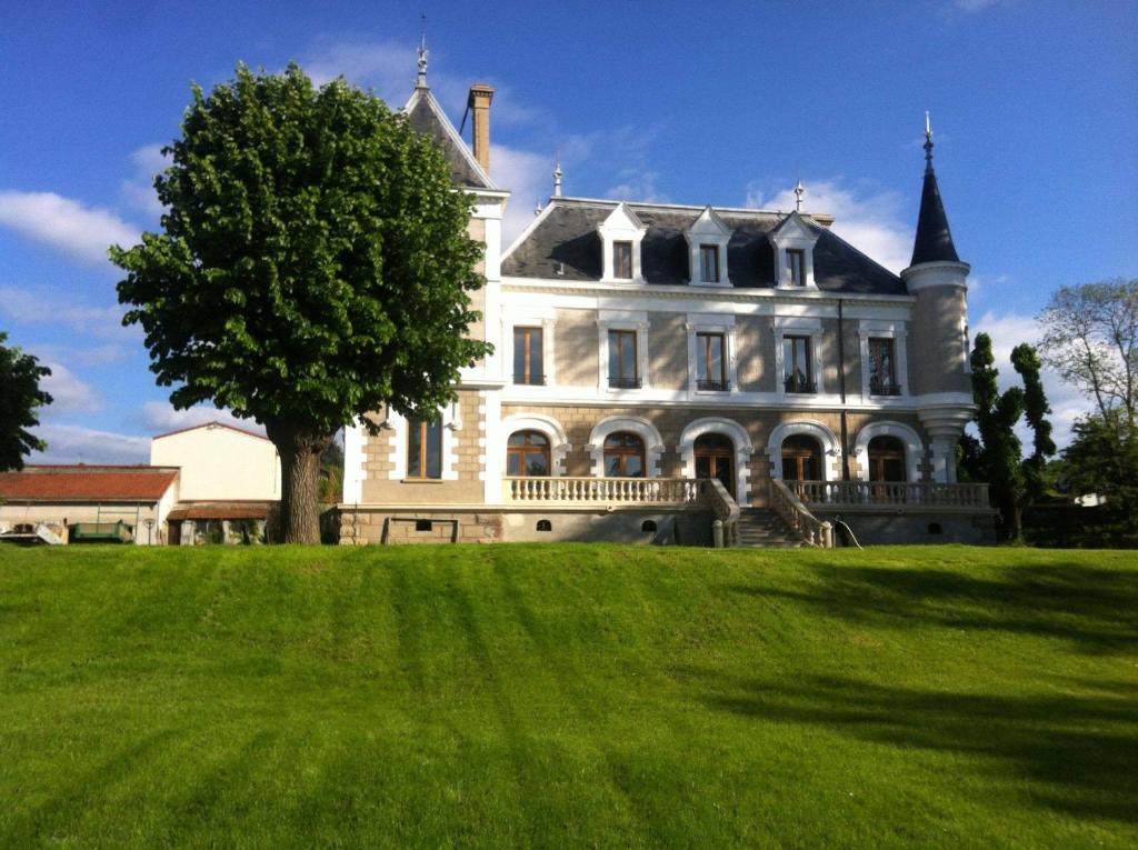 Saint-Paul-en-Jarez的住宿－Eclosion Château Hôtel & Restaurant，前面有一棵树的大白色房子