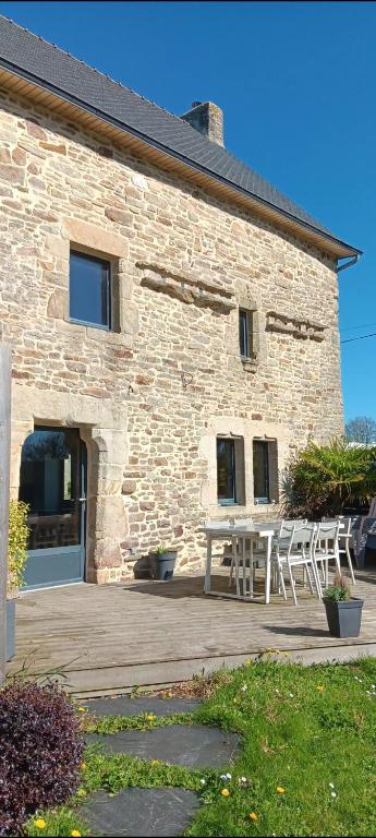 a stone building with a picnic table in front of it at Gîte coup de cœur in Pluvigner