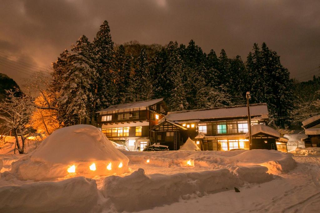 a house covered in snow at night with lights at Setoguchi in Tokamachi