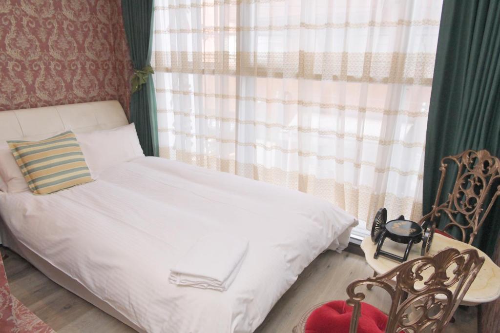a bedroom with a white bed and a window at Hotel Bali Yokohama in Yokohama