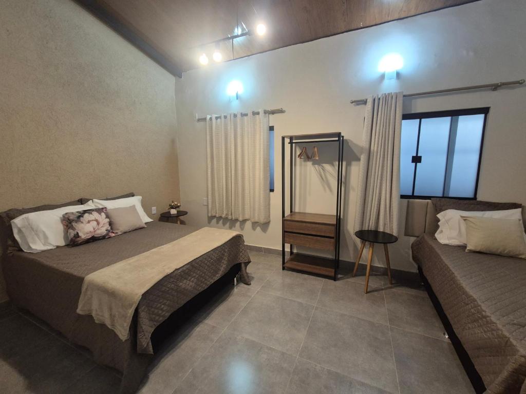 a bedroom with two beds and a mirror at Kitnet Vale do Amanhecer - Templo Mãe in Planaltina
