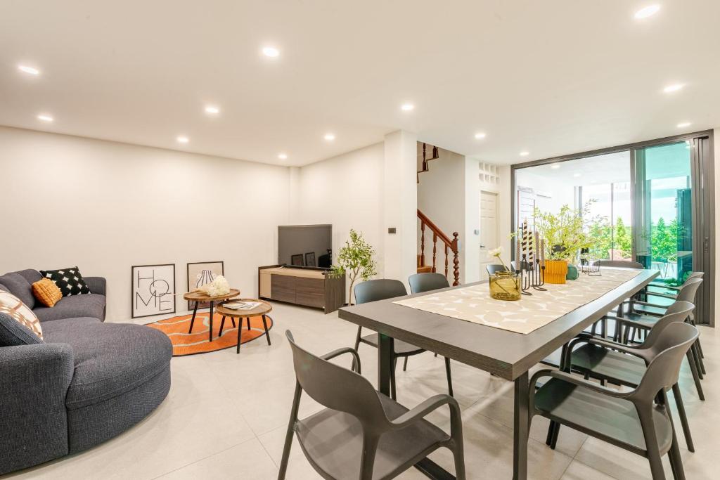 a dining room and living room with a table and chairs at The Mellow at Sathorn in Chinatown