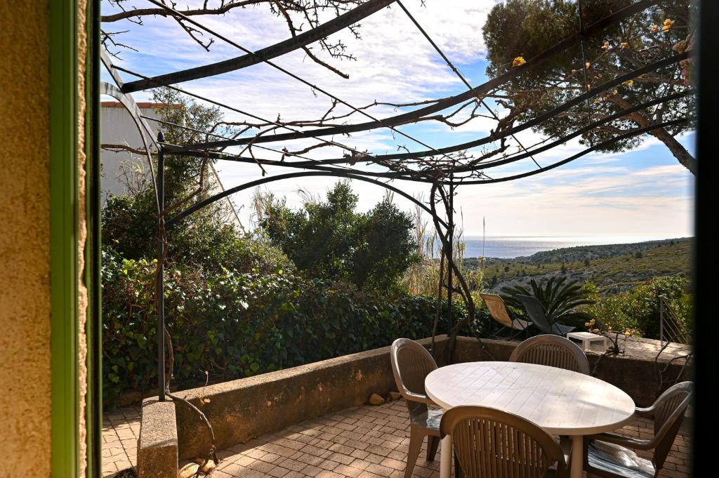 a patio with a table and chairs and a view at Les Cigales in Cassis