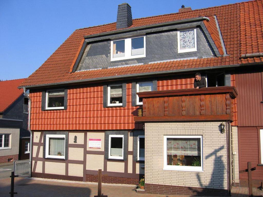 a man looking out of the window of a house at Ferienwohnung-Brenda in Wolfshagen