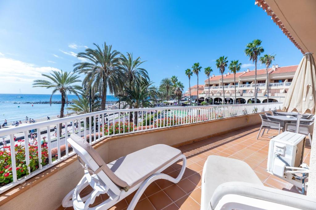 a balcony with chairs and a view of the beach at Apartamentos Vista Sur in Playa de las Americas