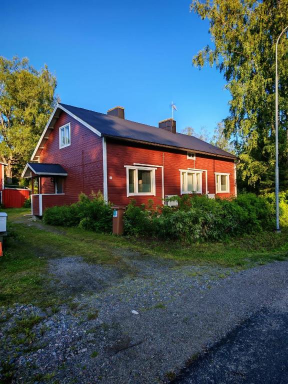 a red house with a black roof at Tunnelmallinen kaksio järven lähellä, vuokraajalle käytössä myös kajakkikaksikko in Heinola