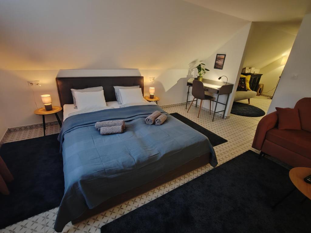 a bedroom with a large bed with two towels on it at MANSARD - Bozsok in Bozsok
