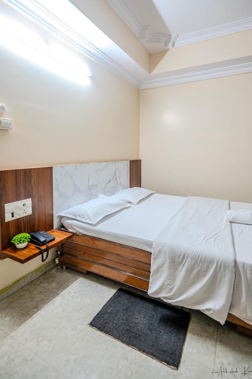 a bedroom with a large bed and a night stand at Laxman Avenue in Jagdalpur