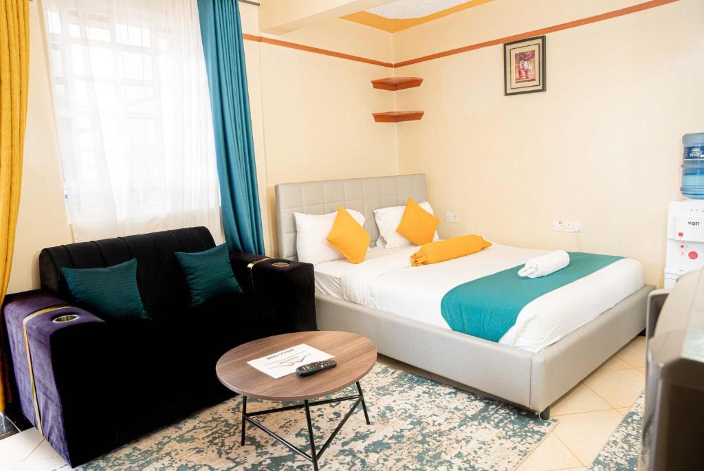 a bedroom with a bed and a couch and a table at Nelly fully furnished studios in Naivasha