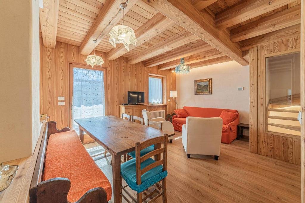 a dining room and living room with a table and chairs at Chalet Dolomites Heart in Feder
