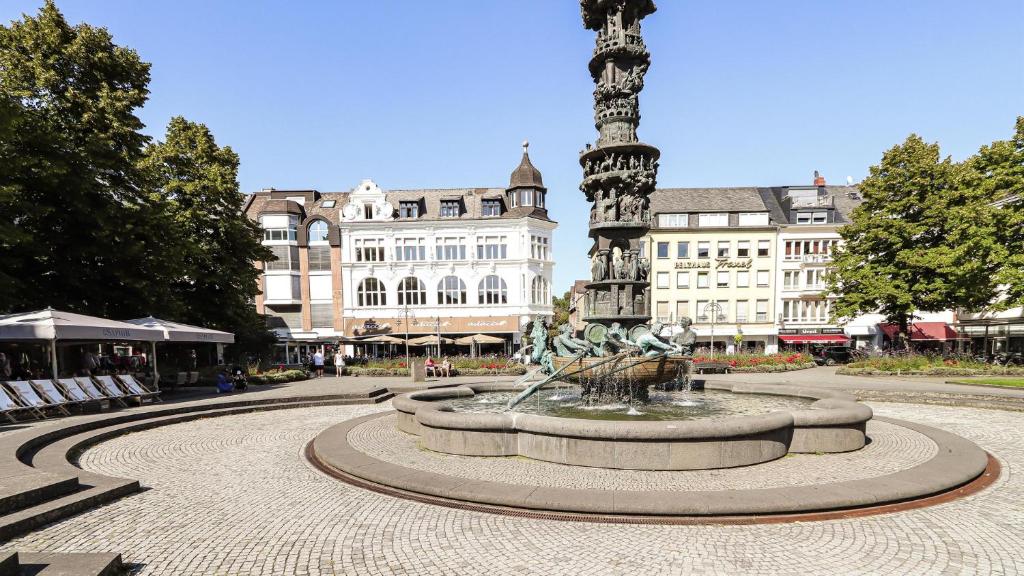 a fountain in the middle of a plaza with a large building at Appartement-Koblenz in Koblenz