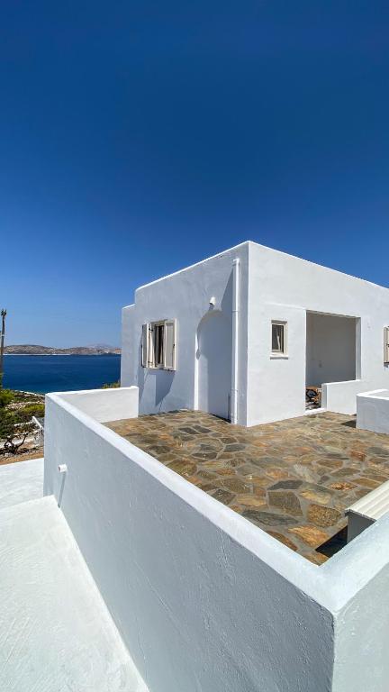 a white building with a stone patio on top of it at Gaia in Agios Georgios