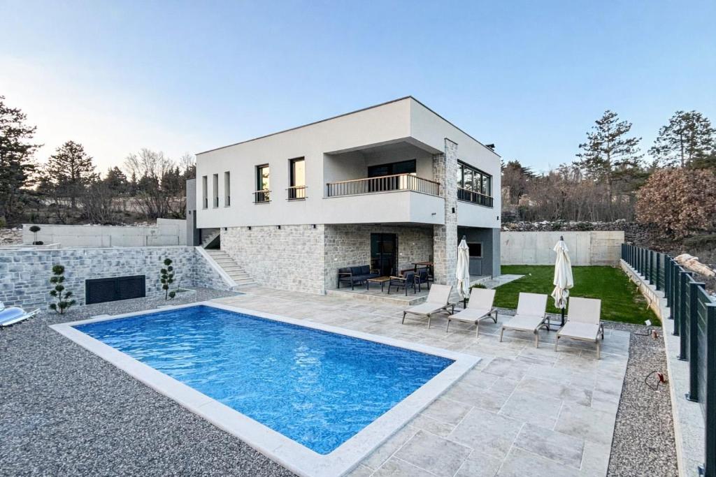 a house with a swimming pool in front of a house at New Villa Oasis in Imotski