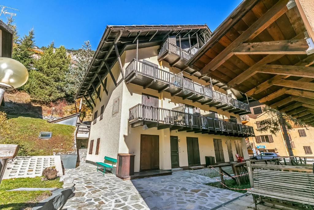 an apartment building with a balcony and a bench at Rochebrune Apartments in Ski Resort in Claviere