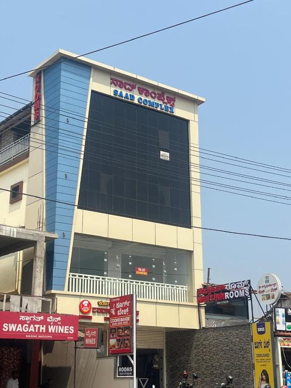 a large building with a sign on the side of it at Nest Inn in Suntikoppa